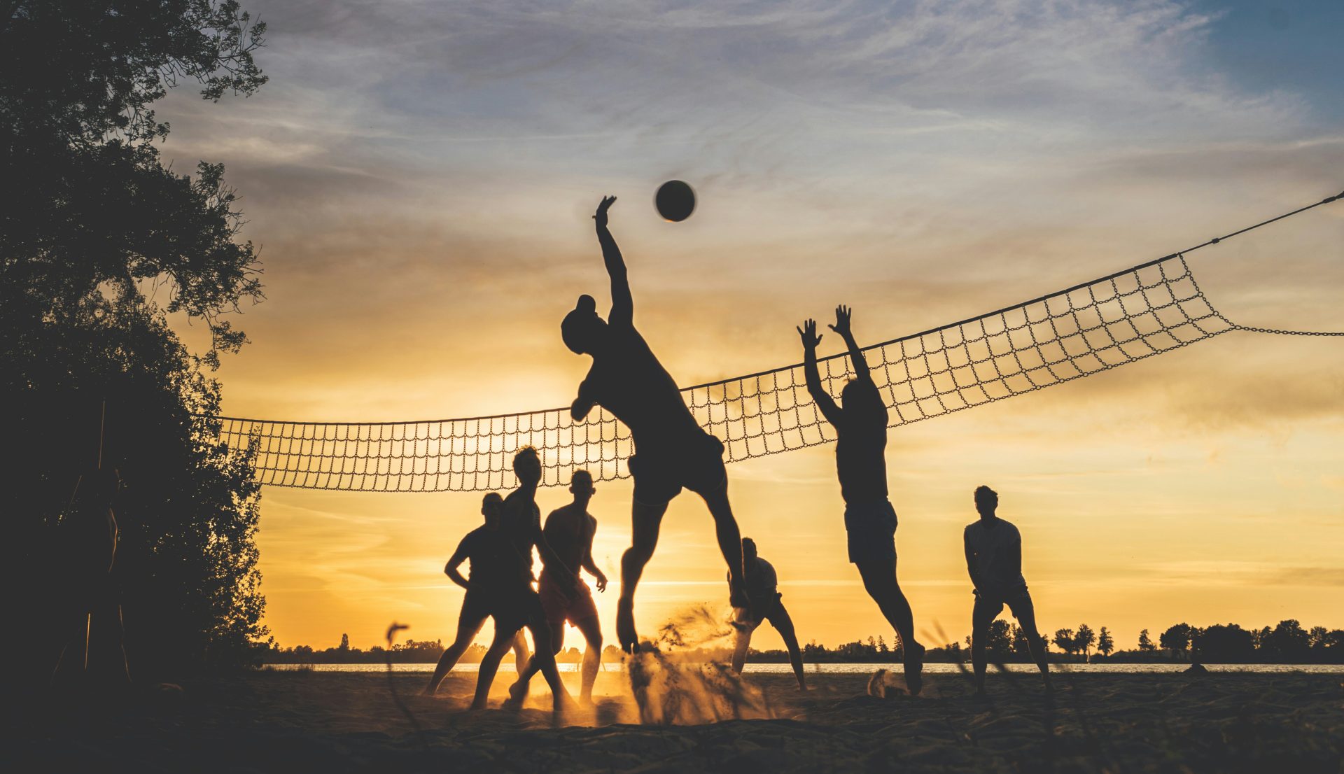 Silhouettes de volleyball au coucher de soleil